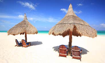 Beach chairs and thatched palapa umbrellas at reso