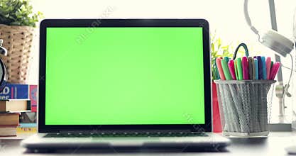 Dolly in of Laptop with green screen. Dark office. Perfect to put your own image or video.Green screen of technology being used.