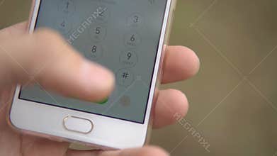 Person dials 911 on the touchscreen phone while in the forest