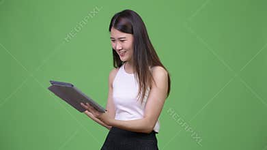 Young beautiful Asian businesswoman using digital tablet