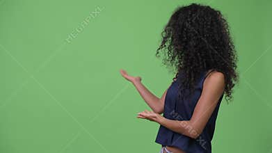 Young beautiful Hispanic businesswoman showing something