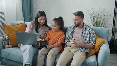 Cheerful woman man and girl using modern devices discussing online content enjoying gadgets