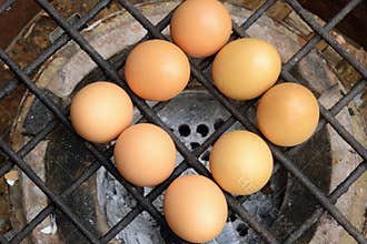 Grilled chicken eggs over stove gridiron.