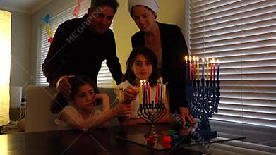 Jewish family kindling candles on the eight day of Hanukkah Jewish holiday festival