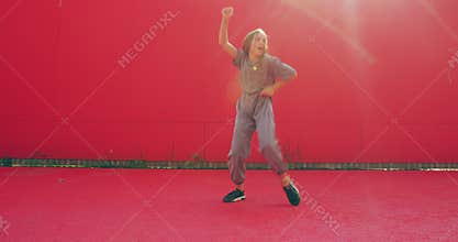 Dancing teen girl perform expressive energetic modern street dance in sunshine outside. Teenager dancer cool moving
