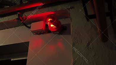 alarm system in the bunker. a red burning siren on the door. red lights are spinning in the corners of the room