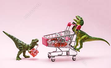 Two cute dinosaurs with shopping trolley full of present boxes on pink background. Sale concept