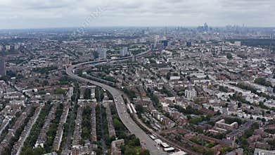 Aerial panoramic view of multilane highway winding through urban neighbourhood. Skyline with modern skyscrapers in