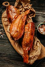 Appetizing smoked fish on the kitchen board. river bass fish on wooden cutting board. delicious snacks for beer