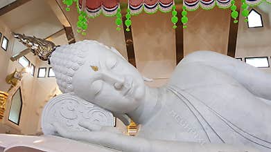 White marbleÂ  reclining Buddha statueÂ  atÂ WatÂ Pa Phu Kon . Photo taken in April 2017 in Udorn Thani province , ThailandÂ 