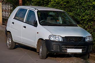 Stock photo of white color car parked outside of the house under bright sunlight at Kolhapur city, Maharashtra, India. selective