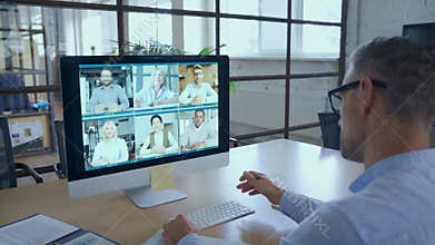Businessman talking with team leading virtual meeting on computer. Over shoulder