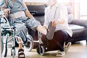 young asian physical therapist working with senior woman on walking with a walker