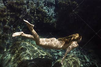 Nude woman underwater.