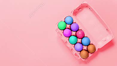 Easter holiday. Packaging of chicken eggs changing colors on pink background. Copy space. Banner. Video footage. Mockup