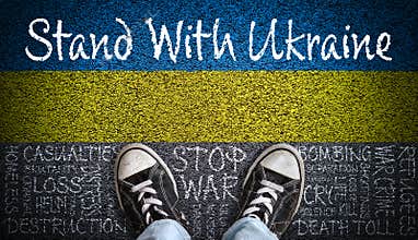 Stand With Ukraine Message on Asphalt With Painted Flag and Stop War Word Cloud