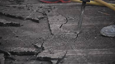 Workers on a road construction sites. They are removing the old asphalt layer using pick hammers