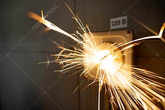 Power outlet with 220 volt cable sparkles with electric sparks
