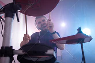 Music, drums, hobby and interests concept - Emotional drummer plays the drums. Photo with lighting motion effect