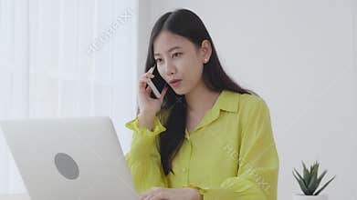 Young asian business woman working form home office and call phone for success at home.