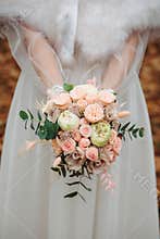 Bride holds a wedding bouquet of flowers
