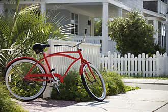 Red bicycle in front of house.