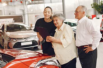 Stylish and elegant old couple in a car salon