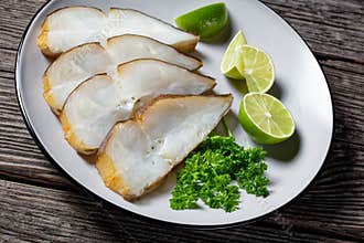 Halibut fish slices on a plate, top view