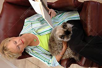 Senior woman reading with cat