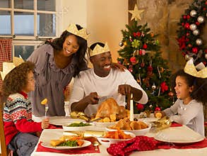 Mixed race family having Christmas dinner