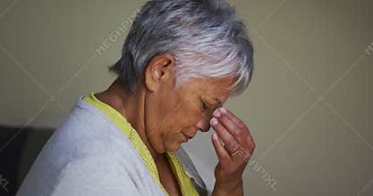 Senior mixed race woman with headache sitting touching brow