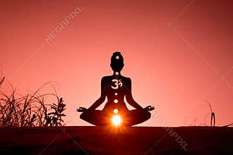 Silhouette of a person doing yoga with the root chakra symbol