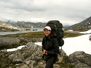 Girl hiking in snowfield and rockfield