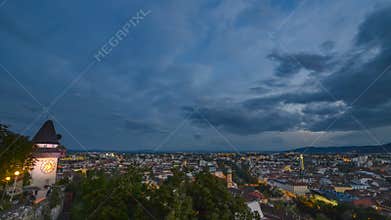 Sunset over Graz skyline 4K timelapse with famous Clock Tower on Schlossberg hill and historic buildings, in Graz, Styria region,