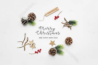 Top view of holly berry plants, fig branches, and pine cones with \"Merry Christmas & Happy New Year