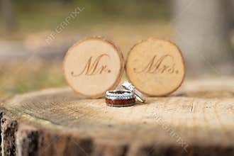 Closeup of the wedding rings with the \" Mr. Mrs.\" written on the two wood