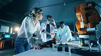 Researchers are using VR-device for a robotics experimentProfessional engineers working with innovative equipment