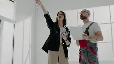 Apartment designer shows photos to foreman on cellphone