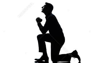 Silhouette man kneeling praying full length