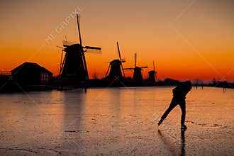 Ice skater in front of the Kinderdijk windmills