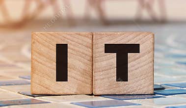 IT letters on Wooden Cubes on swimming pool borders. business concept