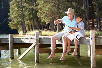 Senior man fishing with grandson