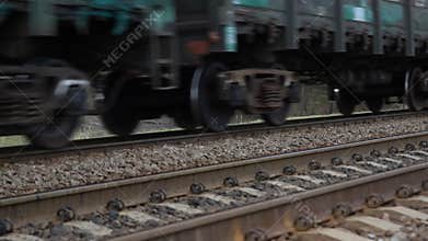 Motion blurred heavy cargo freight rusty train wagons moving on railway on overcast day time. Industrial materials