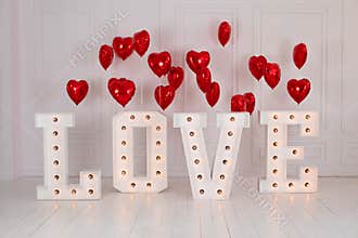 Love big letters with led retro bulbs glowing. Word LOVE illuminated with a big letters. Inscription is love. Glowing large letter