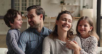Portrait of happy sincere bonding family posing at home.