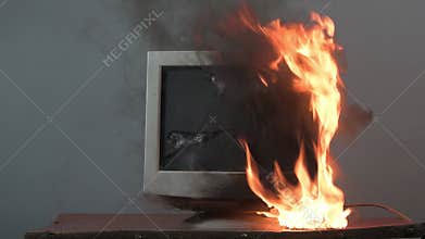 The computer monitor is on fire, the fire spreads over the computer equipment. A brick breaks the monitor, the table overturns, th