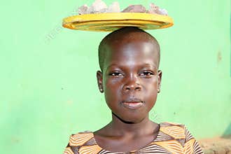 African girl carying stones on her head