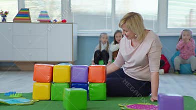 male child with down syndrome has fun playing with a female teacher during developmental activities in an inclusive