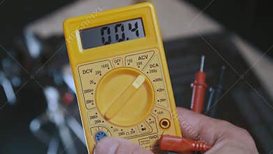 A man changes multimeter knob position