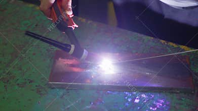 Man wearing mask welding in a workshop. Metal workers use manual labor. Skilled welder. Welder is welding the stainless